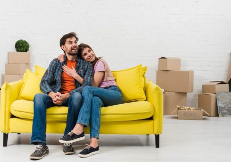 Casal em sofá na casa nova