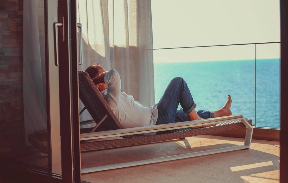 homem na varanda de apartamento na praia
