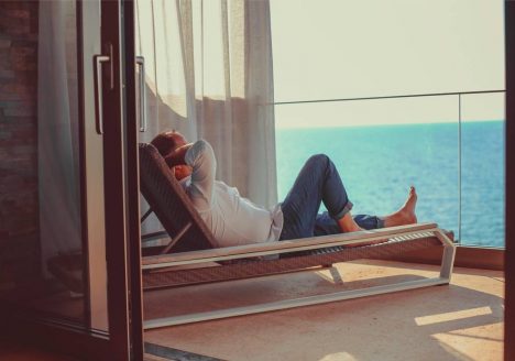 homem na varanda de apartamento na praia