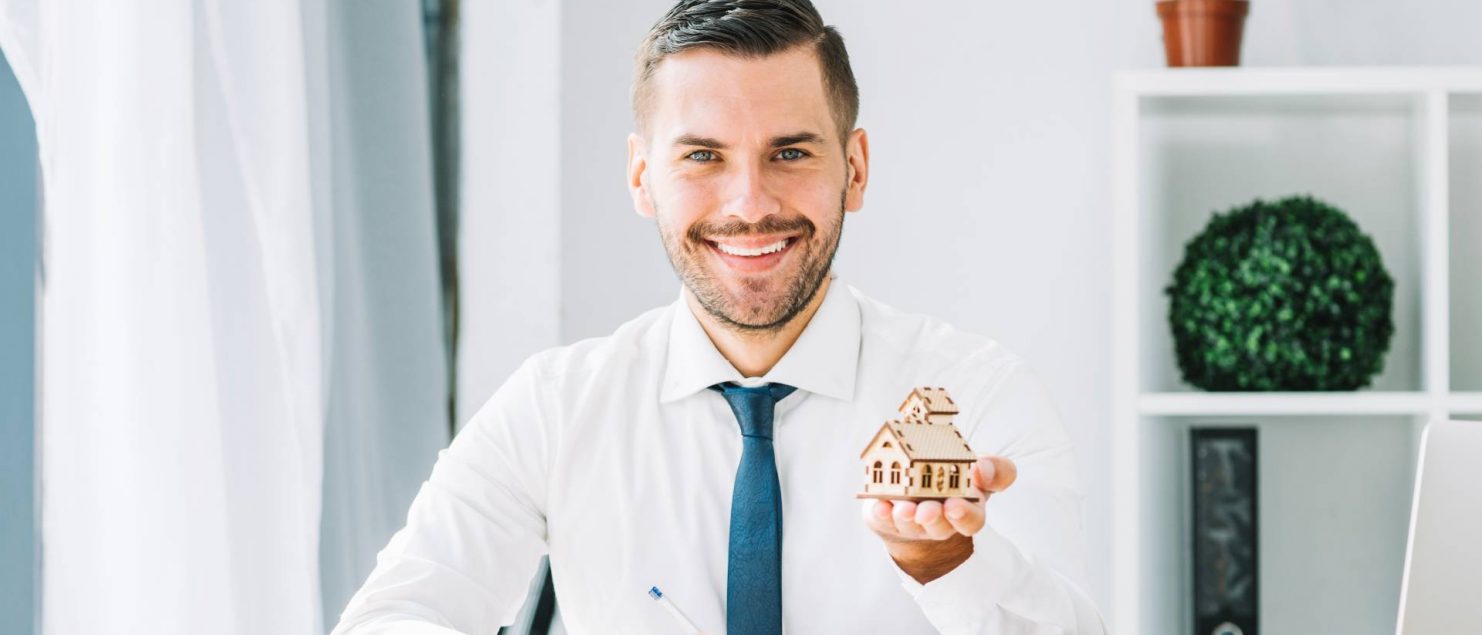 homem jovem com maquete de casa na pauta na mão