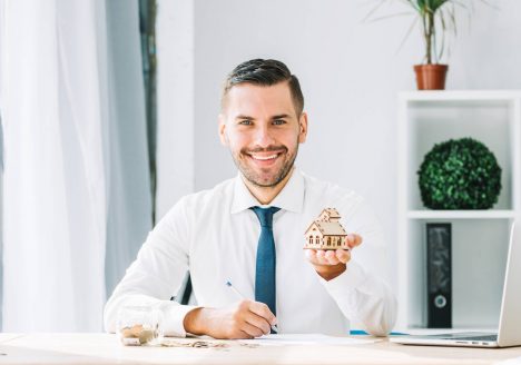 homem jovem com maquete de casa na pauta na mão