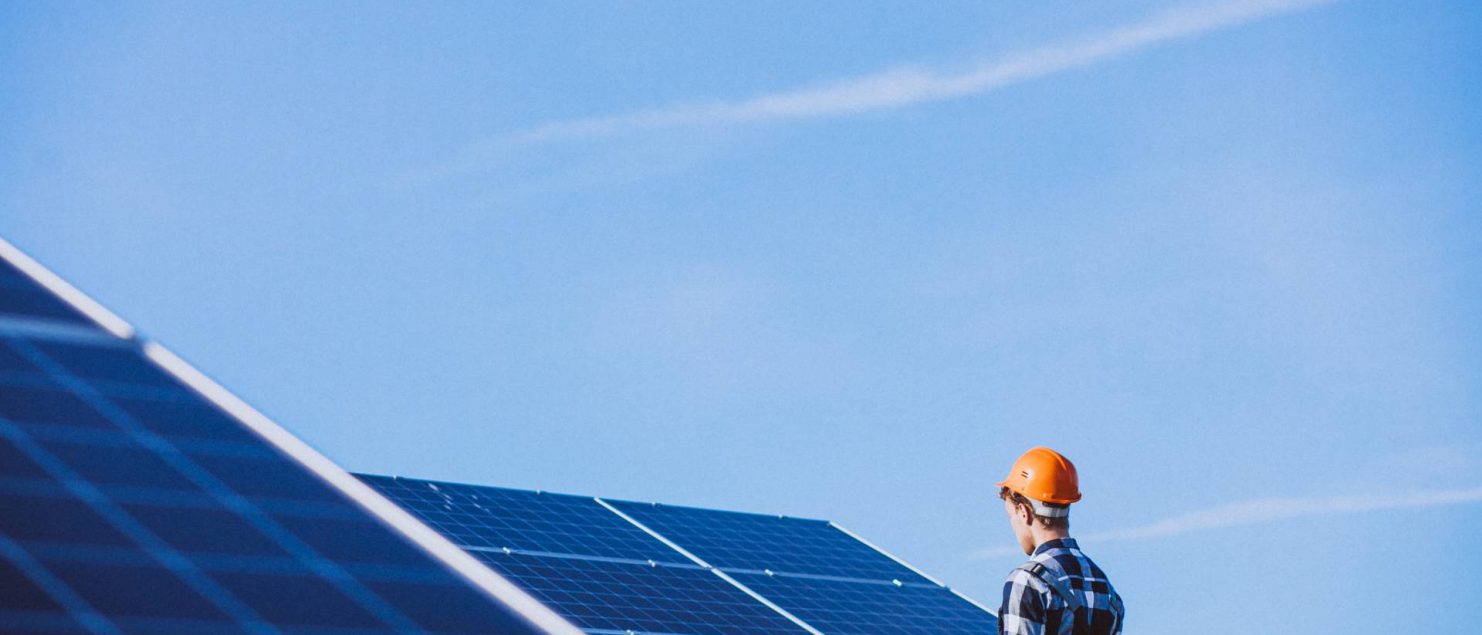 homem em cima de telhado de placas solares