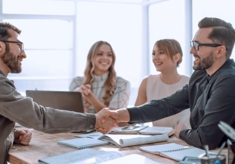 duas mulheres e um homem fechando uma compra de imóvel