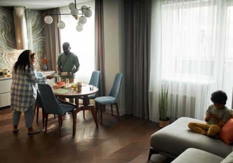 Família preparando mesa de café da manhã em um apartamento mobiliado